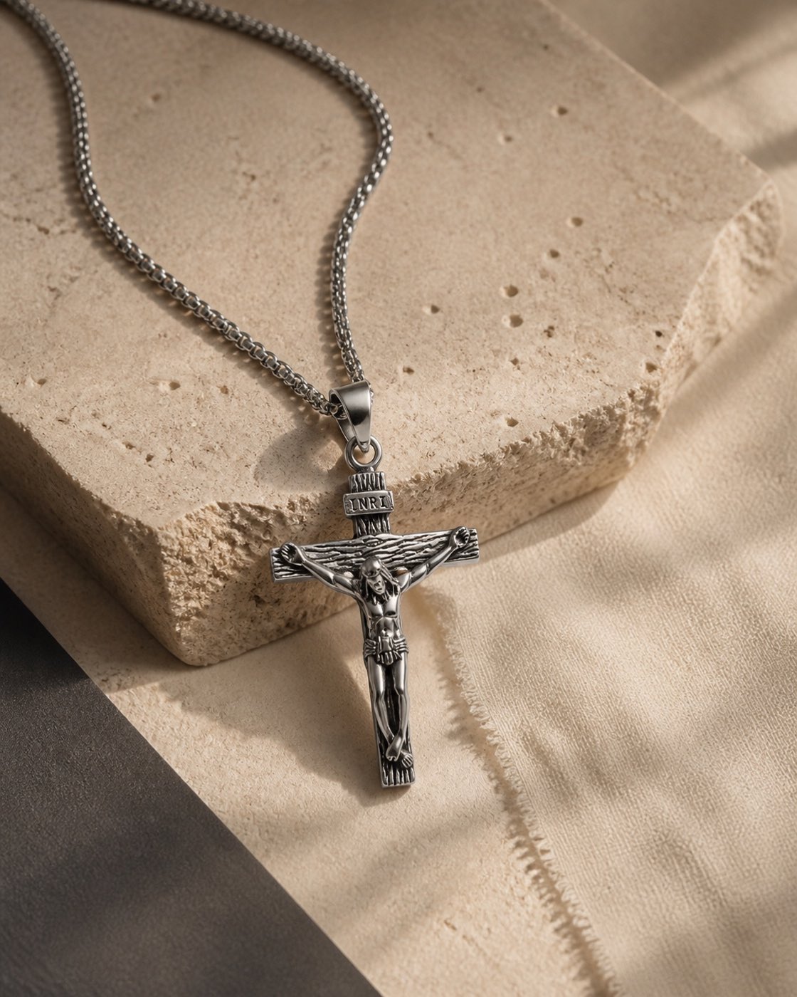 Silver King's Ransom crucifix chain styled on warm limestone