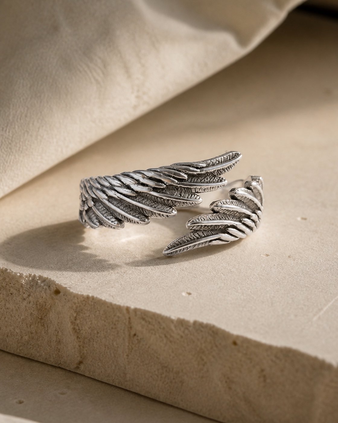 Silver Wings of Light ring styled on warm limestone